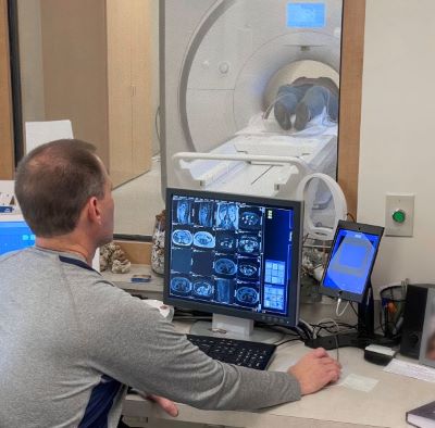 Doctor looking at patient's scan while patient is in MRI machine