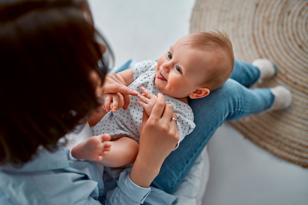 Women playing with her newborn baby.